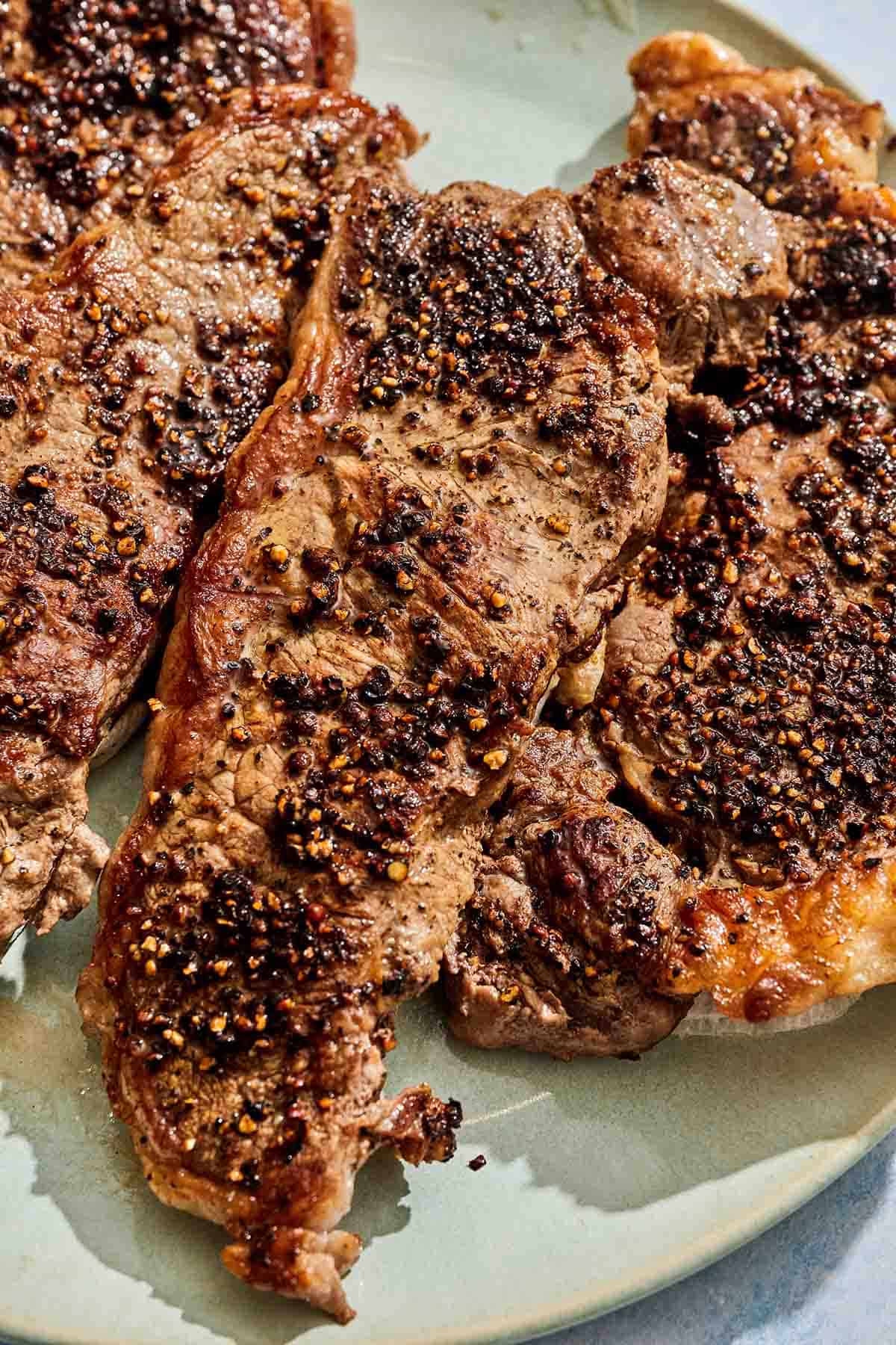 The the steaks for the steak au poivre with a peppercorn crust on a platter.