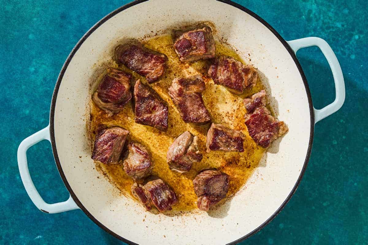 The beef for the beef tagine being browned in a skillet.