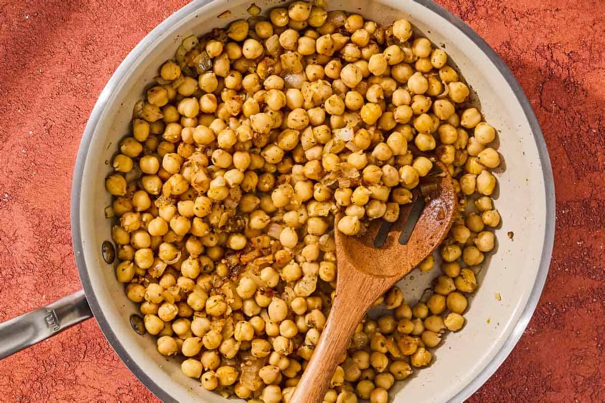 The chickpeas for the chickpea skillet being toasted with a wooden spoon.