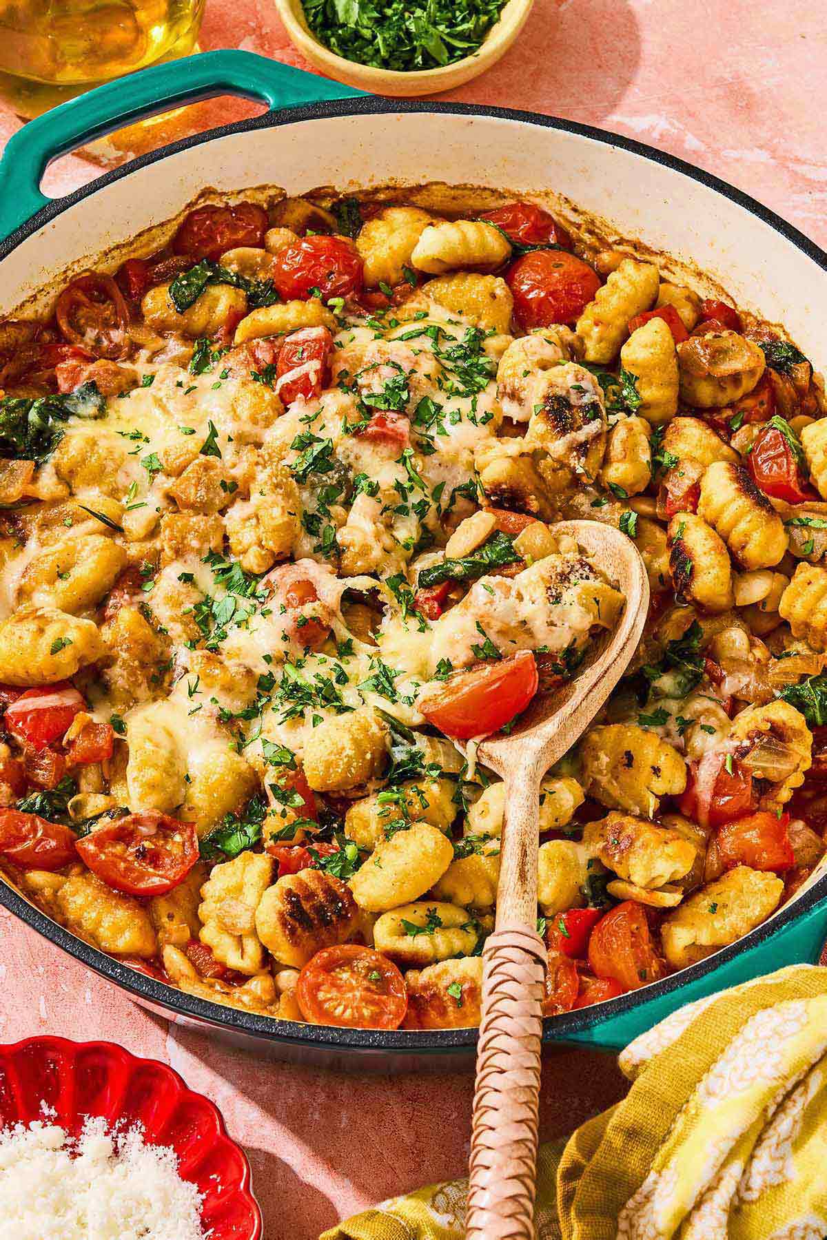 Skillet gnocchi in a skillet with a wooden spoon.