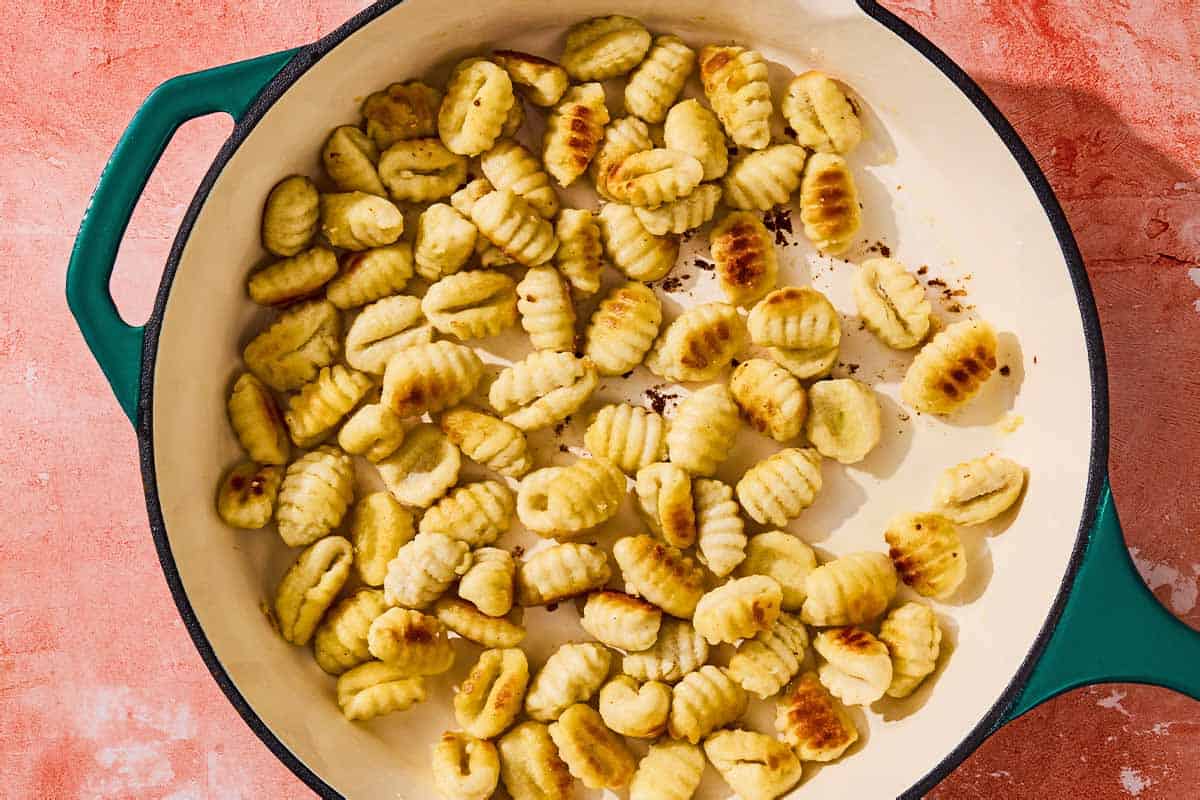 Gnocchi being toasted in a skillet.